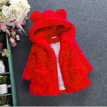 Red children's coat with bear ears on a gray surface
